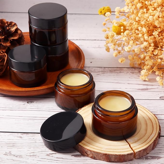 Domensi 100 Pcs 1oz Glass Jars with Lids Bulk Small Glass Salve Tins Cream Container Cosmetic Jars for Travel Balm with Inner Liners for Sample Cream (Amber,Black Lid,Plastic Lid)